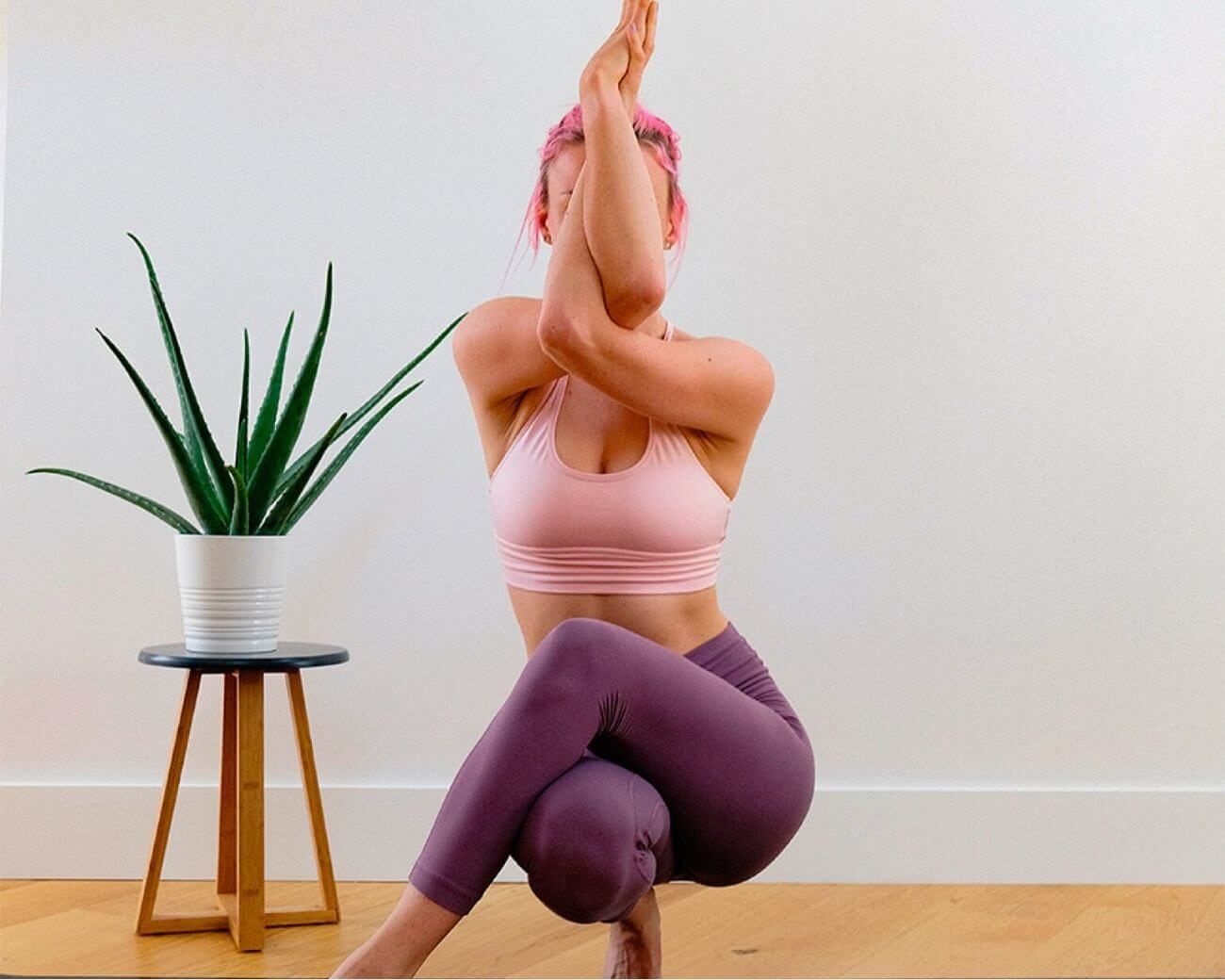 Fotografía de una mujer realizando una posición de yoga en su casa